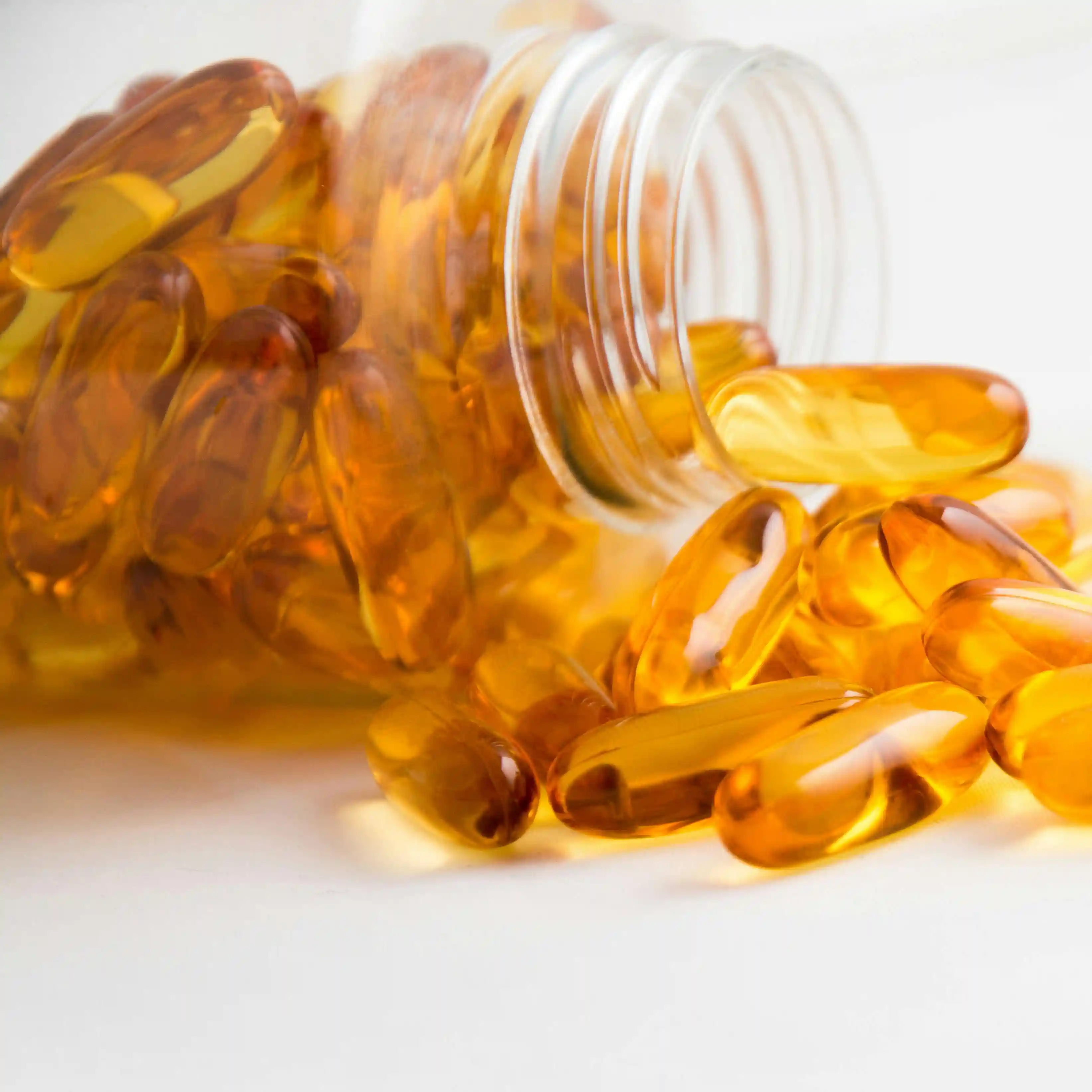 Immagine di pillole gialle che fuoriescono da bottiglia rovesciata.